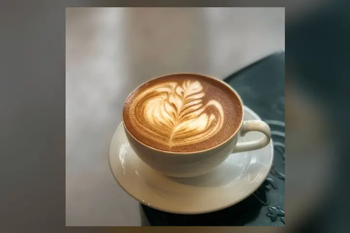 A cappuccino with latte art on a saucer